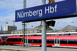 Regionalzug am Bahnsteig des Nürnberger Hauptbahnhofs mit Beschilderung "Nürnberg Hbf"