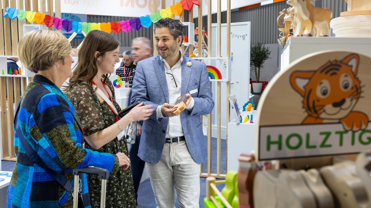 Aussteller im Gespräch mit eingeladenen Kunden auf einem Stand im Verkaufsgespräch.
